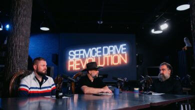 Service manager holding a focused one-on-one coaching meeting with a service advisor